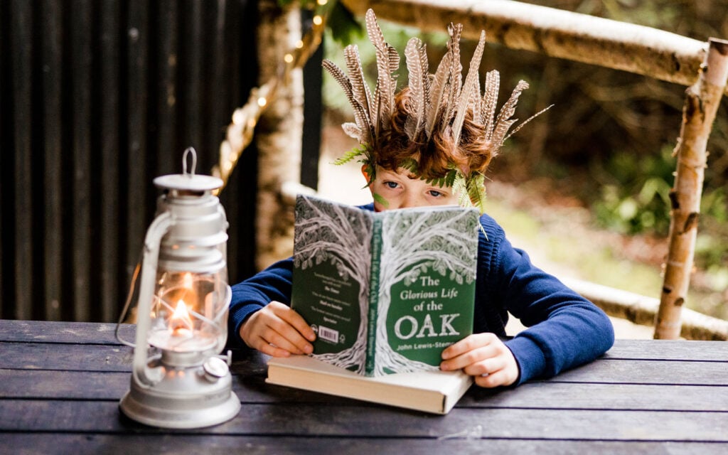 Child reading a book outdoors at a woodland retreat