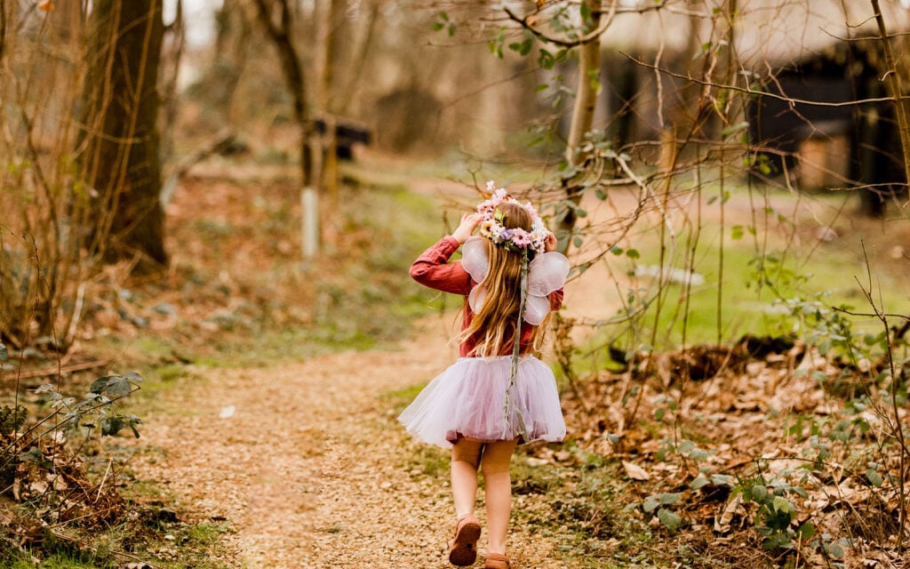 Child dressed as a fairy walking along a woodland path at The Dreamery Hideaway