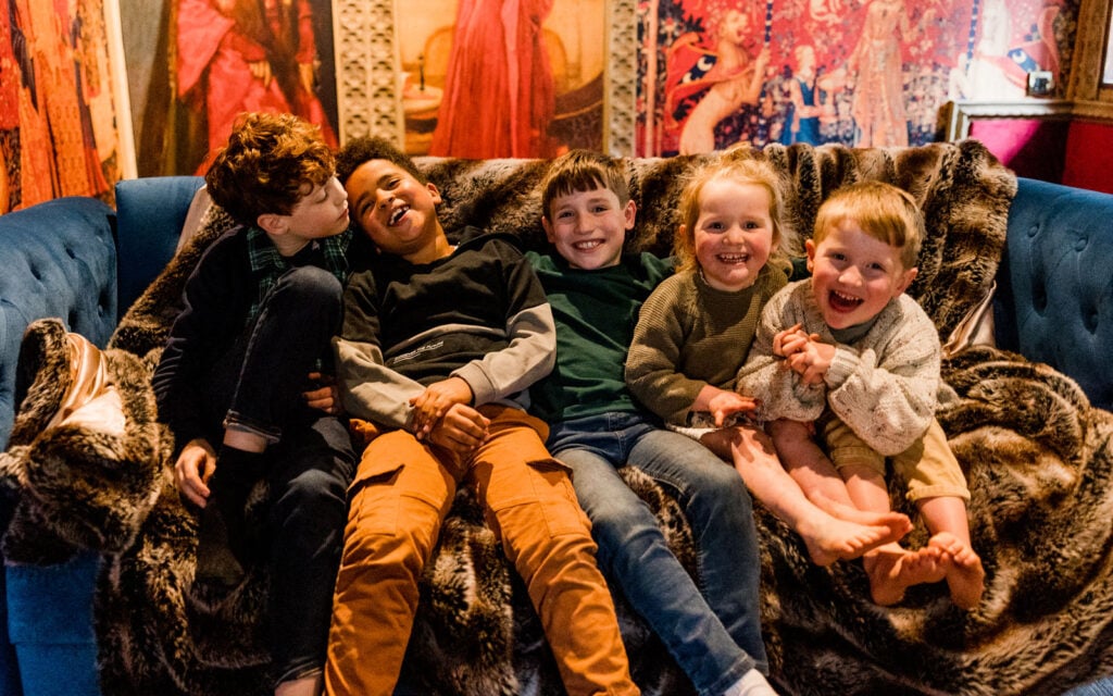 Children relaxing together inside a Dreamery Hideaway bothy