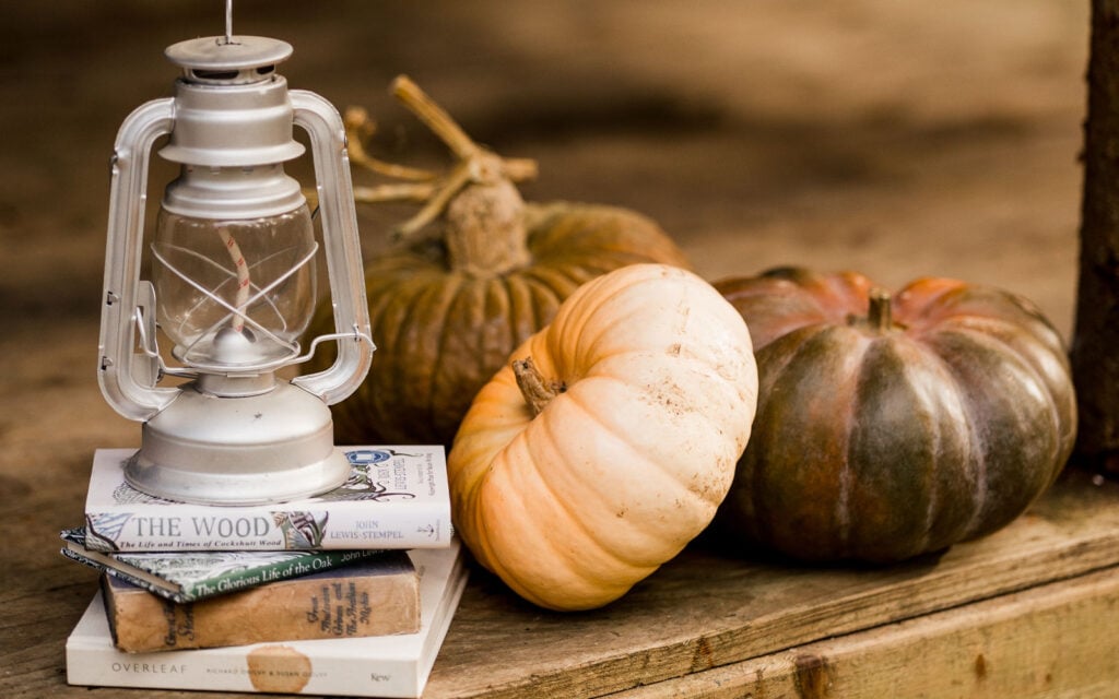 Rustic lantern and pumpkins on a wooden table at The Dreamery Hideaway
